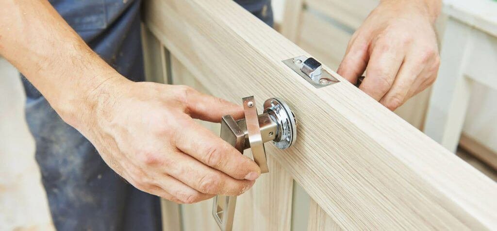 Expert installation of contemporary metal hardware on a timber door