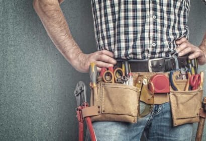 Close-up of a worker's tool belt with various hand tools